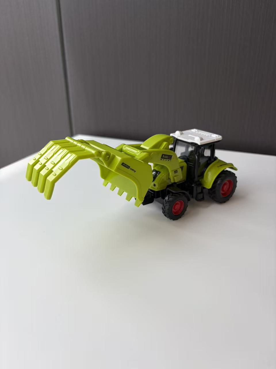 Green Compact Loader Backhoe Model with Front Bucket and Rear Arm